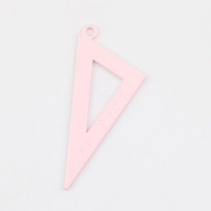 Macro detail of a pink alloy triangle pendant with engraved scales for DIY jewelry making