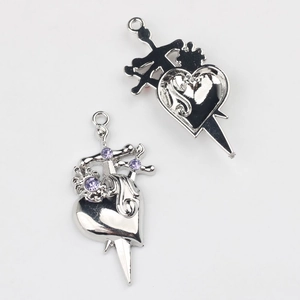 Detailed view of silver heart and sword alloy pendants with purple rhinestones for DIY jewelry