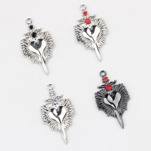Macro detail of alloy heart dagger pendants with colorful zircon stone inlay