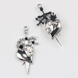 Macro view of gothic heart dagger charms with black stones for DIY jewelry making