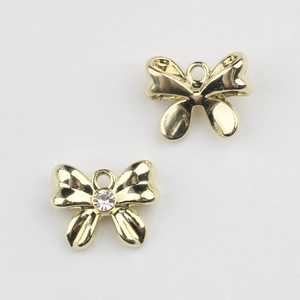 Detalle de colgantes de lazo dorado con perlas y circonitas para creación de joyería