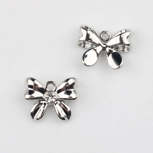 Detalle de dijes de mariposa plateados con circón para creación de joyería artesanal