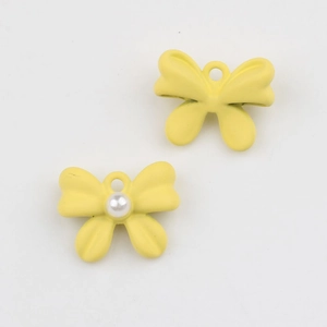 Detalle macro de colgantes de mariposa amarillos mate con perla para bisutería DIY