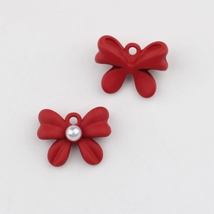 Detalle de dijes de lazo rojo mate con perlas para manualidades de joyería DIY