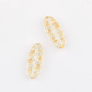 Detailed macro of gold-etched leaf glass beads for DIY vintage jewelry making