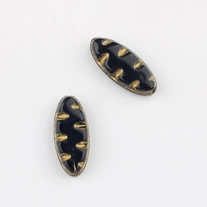 Detail showing two black oval glass beads with vintage gold leaf pattern engravings