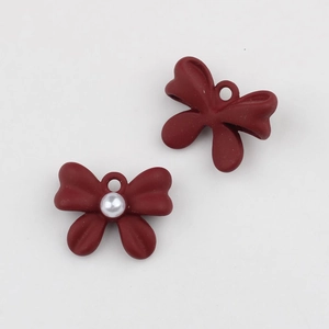 Detalle del colgante de lazo rojo mate con perla blanca para creación de joyería DIY