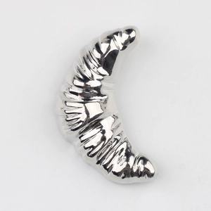 Détail d'un pendentif croissant en argent poli avec des textures de métal plié