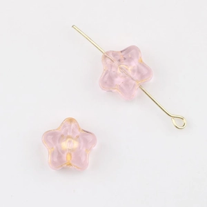 Macro view of pink star-shaped Czech glass beads with gold gilded edges for DIY jewelry
