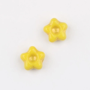 Detail of yellow star-shaped Czech glass beads with gold gilded center for DIY jewelry