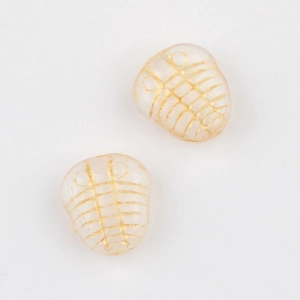 Dettaglio macro di perline trilobite con bordi dorati e resina rosa traslucida
