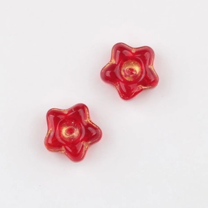 Macro shot of red glass flower beads with vintage gold details for DIY jewelry making