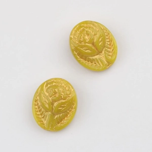 Close-up of yellow oval Czech glass beads with embossed rose pattern and gold details