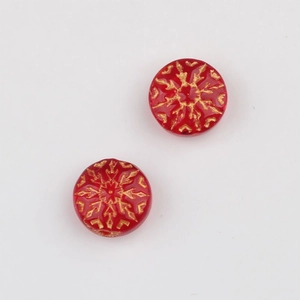 Detalle macro de cuentas de vidrio checo rojas con copos dorados para joyería artesanal
