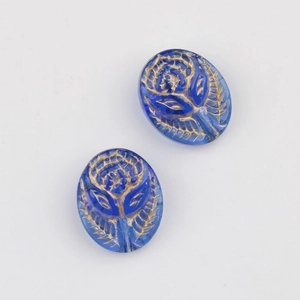Detailed view of vintage Czech glass beads with gold-rimmed rose relief and floral texture
