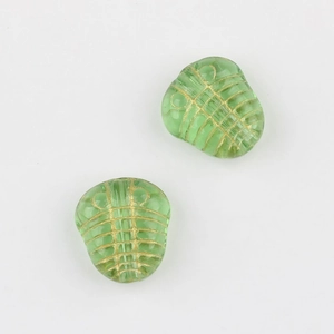 Dettaglio di perline trilobite in vetro ceco verde con linee dorate per gioielli DIY