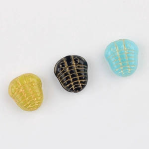 Dettaglio delle perle di trilobite in vetro ceco con accenti dorati per gioielli