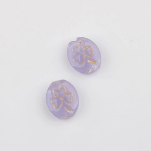 Macro detail of lavender glass beads with gold clover etching for DIY jewelry making
