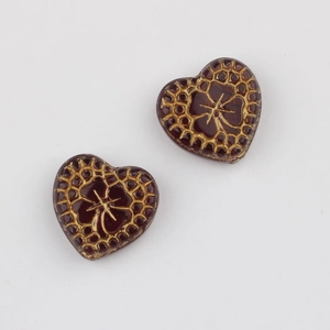Detail of vintage heart-shaped Czech beads with gold floral patterns for DIY jewelry