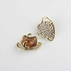 Macro view showing golden cat pendant with amber resin and moon motif detail