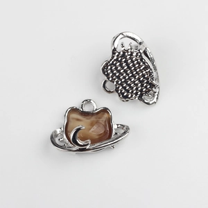 Detailed view of silver cat charm with marble resin inlay and crescent moon accent