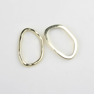 Détail macro de deux anneaux métalliques ovales irréguliers dorés pour bijoux DIY