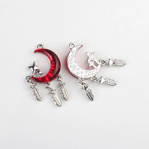 Detail of silver alloy crescent moon charms with red resin and hanging metal feathers