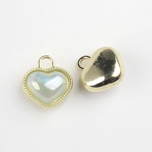 Detail of heart resin pendant with gold alloy border and opalescent finish for DIY