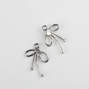 Detalle macro de colgantes de lazo plateado con circonitas para creación de joyas