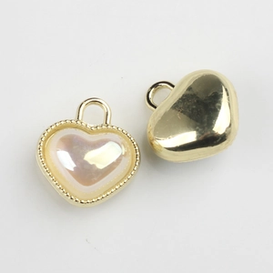 Detail showing heart charm with pearl-like inlay and golden beaded border, front and back