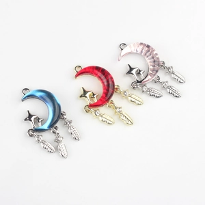 Three celestial moon charms with resin inlay, star accents, and hanging feathers for DIY jewelry