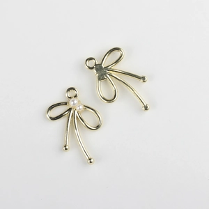 Detalle de colgantes de lazo dorado con perlas blancas para creación de joyería DIY