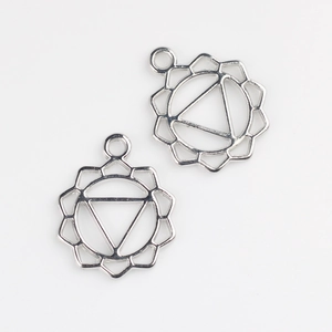 Macro shot of silver alloy mandala sun chakra pendant charms for DIY jewelry making