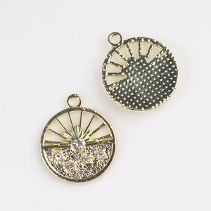 Detail of gold-plated flower pendant with starburst cutout and white rhinestones