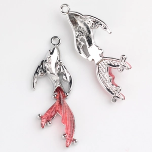 Close-up of silver goldfish charms with red translucent enamel tails for jewelry DIY