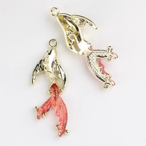 Macro detail of alloy goldfish pendant with red resin tail and intricate scale texture