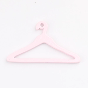 Dettaglio di una piccola gruccia rosa per vestiti da bambola con gancio minimale