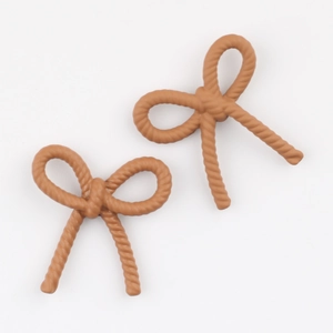 Détail de breloques nœuds marron pour bricolage avec texture torsadée et fini mat