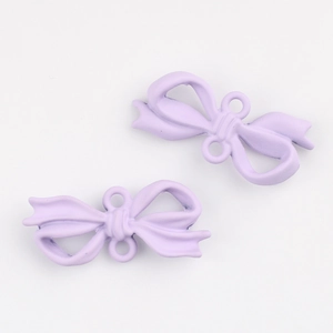 Macro detail of lavender matte alloy bow pendants with dual link rings for DIY jewelry