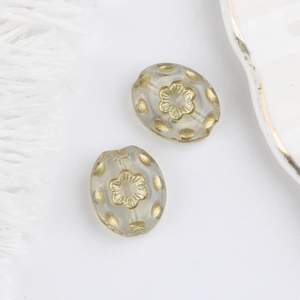 Detailed view of Czech glass beads with gold floral motifs for jewelry making