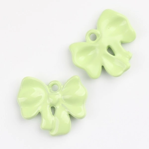 Detail of light green enamel bow charms with polished finish for DIY jewelry crafts