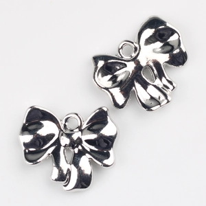Close-up of metallic silver bow charms for DIY jewelry making with a polished mirror finish