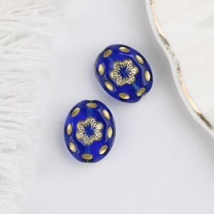Close-up of blue Czech glass beads with gold floral pattern for DIY jewelry making