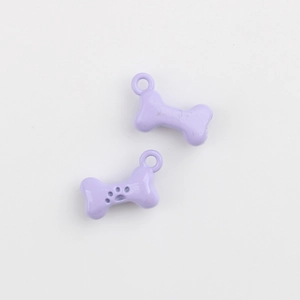 Macro shot of two bone-shaped lavender enamel pendants with paw print for DIY jewelry