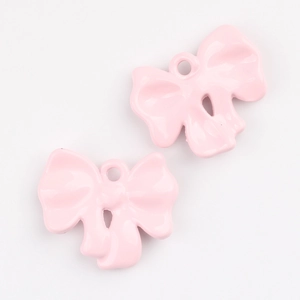 Close-up of pink enamel bow pendant charms for DIY jewelry making accessories
