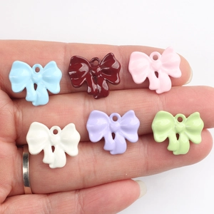 Macro detail of colorful alloy bow pendants for DIY jewelry with small metal rings