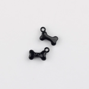 Macro detail of black bone alloy pendant with paw print engraving for DIY jewelry making