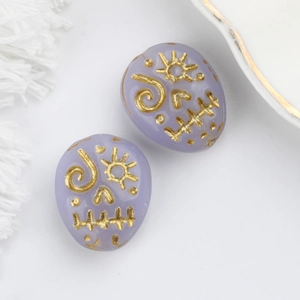 Macro shot of light purple glass beads with gold painted skull for DIY jewelry making
