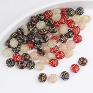 Detail of handcrafted Czech glass ladybug beads with gold accents for jewelry making