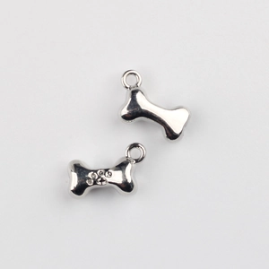 Detailed view of silver bone-shaped alloy pendants with paw print and metal rings
